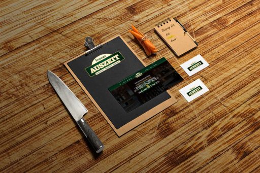 verschiedene Medien im Design von AUSZEIT mit der Webseite im Mittelpunkt