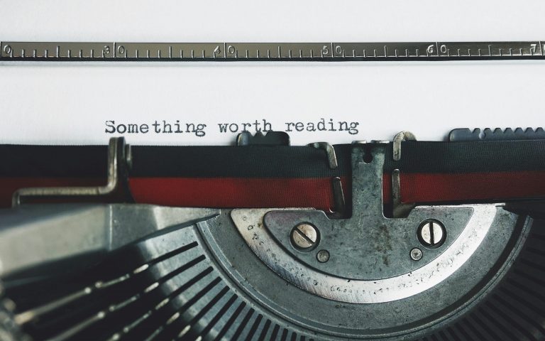 Schreibmaschine mit einem Blatt auf dem steht: something worth reading